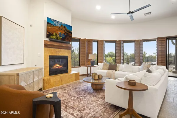a living room with furniture large window and a fireplace