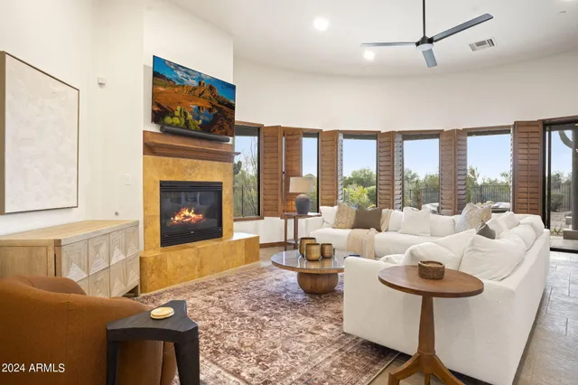 a living room with furniture large window and a fireplace