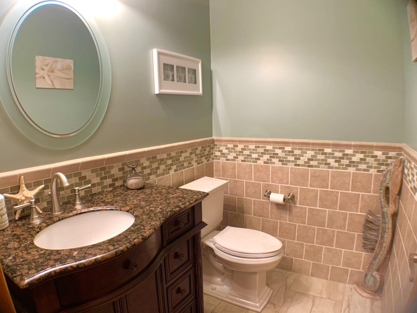 5 Spruce Street East Hampton, NY 11937 - Photo 10 of 16 Half bath with vanity, tile walls, toilet, marble finish floor, and wainscoting