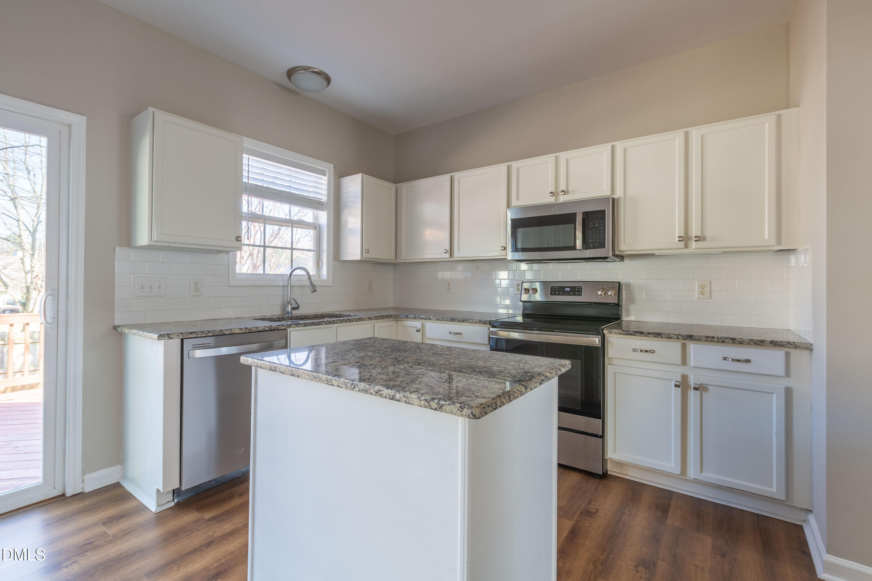 2339 School Creek Place Raleigh, NC 27606 - Photo 15 of 59 a kitchen with granite countertop white cabinets appliances a window and a sink