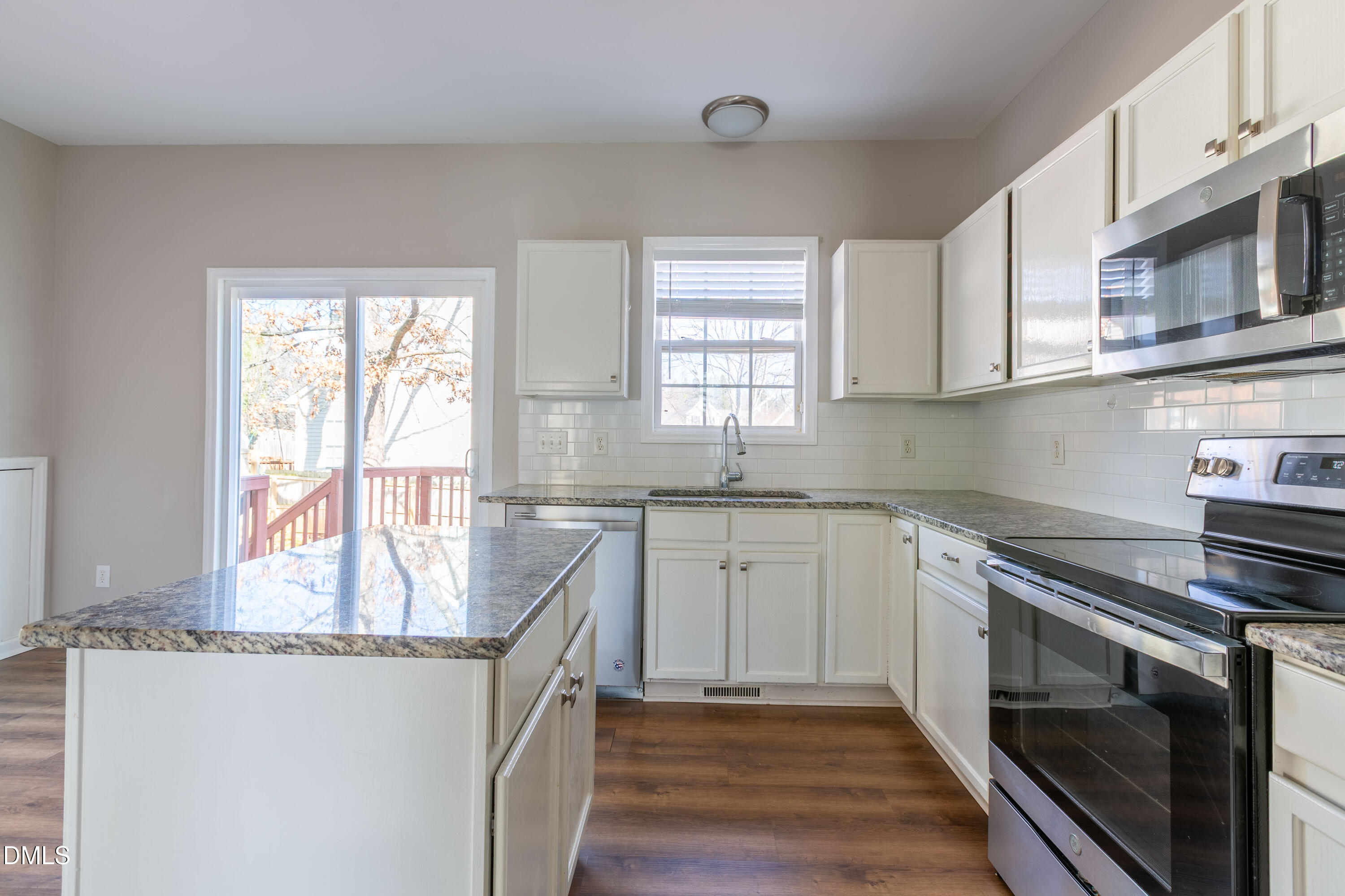 2339 School Creek Place Raleigh, NC 27606 - Photo 16 of 59 a kitchen with granite countertop a sink stove and cabinets