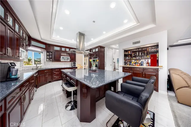 a kitchen with stainless steel appliances granite countertop a table chairs and a refrigerator