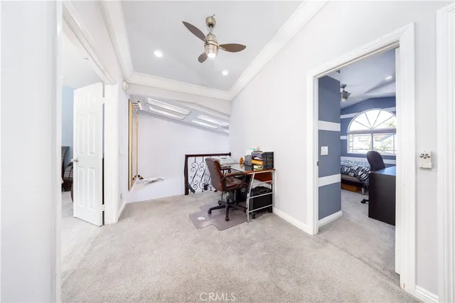 a view of a livingroom with a chair and a ceiling fan