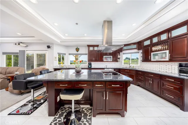 a kitchen with stainless steel appliances granite countertop table chairs sink and wooden cabinets