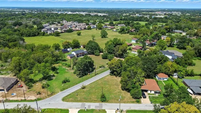 an aerial view of green landscape with trees houses and mountain view