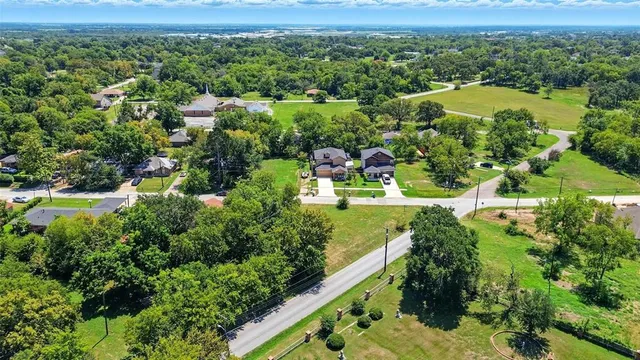 an aerial view of residential houses with outdoor space and city view