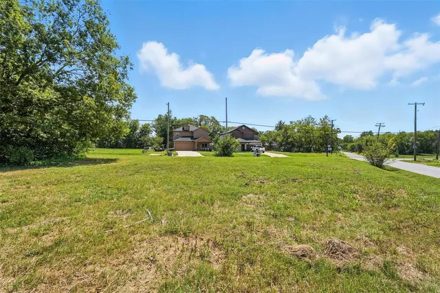 a view of a green field with wooden fence