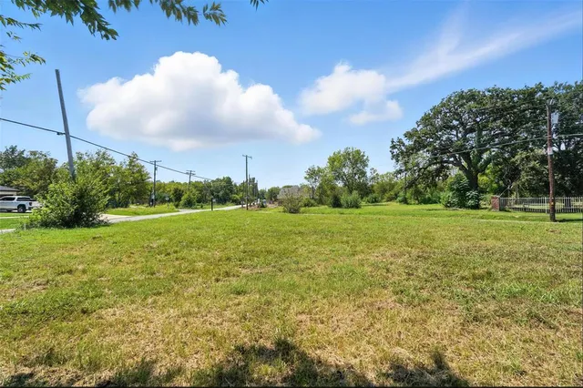 a view of a green field with wooden fence