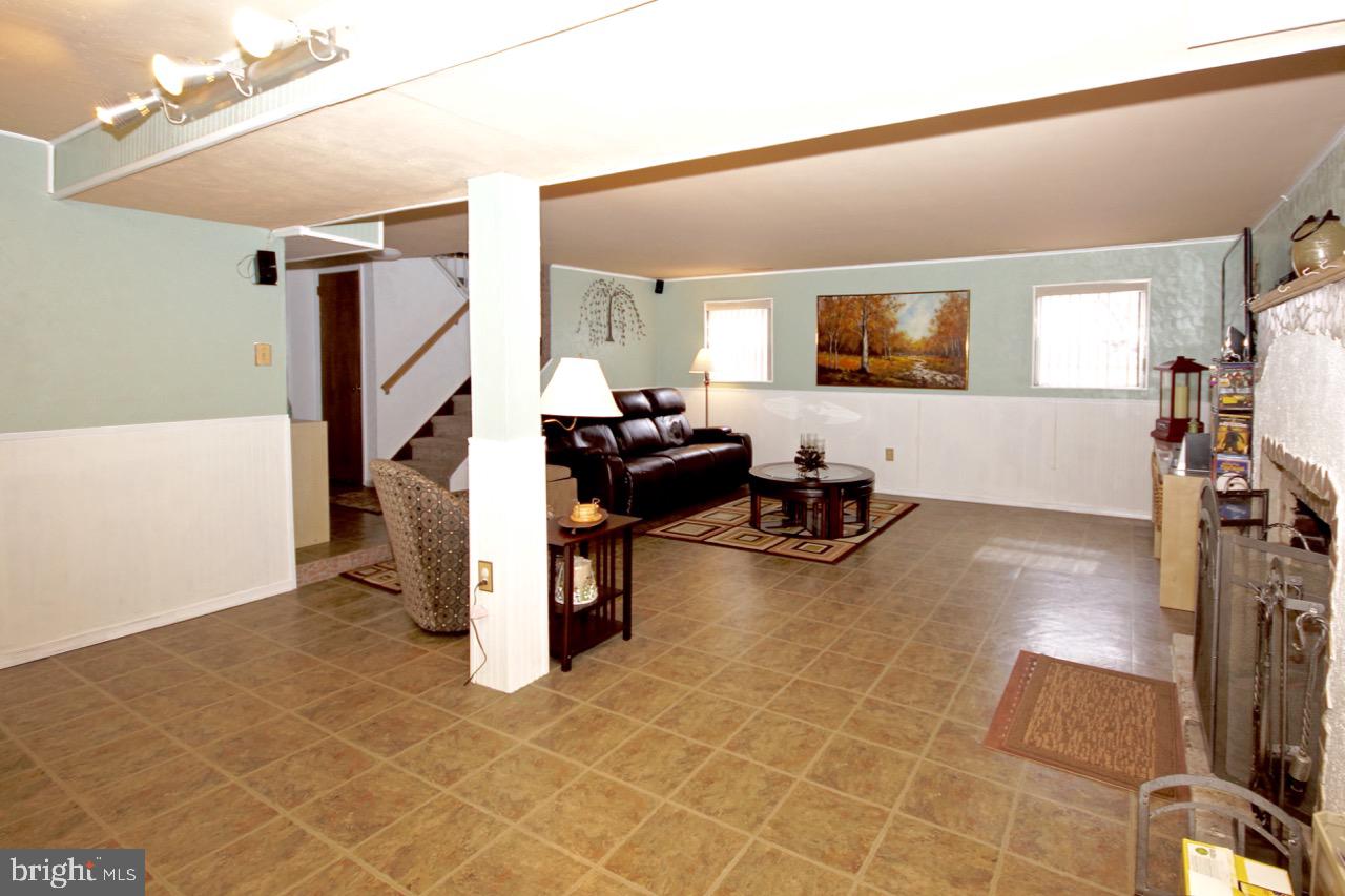 14 Constitution Road Clementon, NJ 08021 - Photo 16 of 27 a living room with furniture a flat screen tv and gym equipment