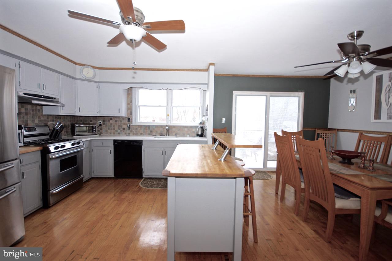 14 Constitution Road Clementon, NJ 08021 - Photo 7 of 27 a kitchen with stainless steel appliances granite countertop wooden cabinets a dining table and chairs
