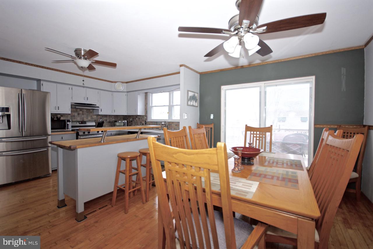 14 Constitution Road Clementon, NJ 08021 - Photo 8 of 27 a kitchen with stainless steel appliances kitchen island granite countertop a table chairs and a refrigerator