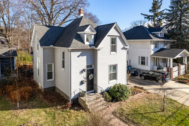 a view of house with yard outdoor seating and covered with trees