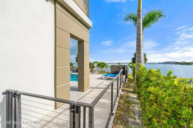 a view of a patio with table and chairs potted plants and palm tree