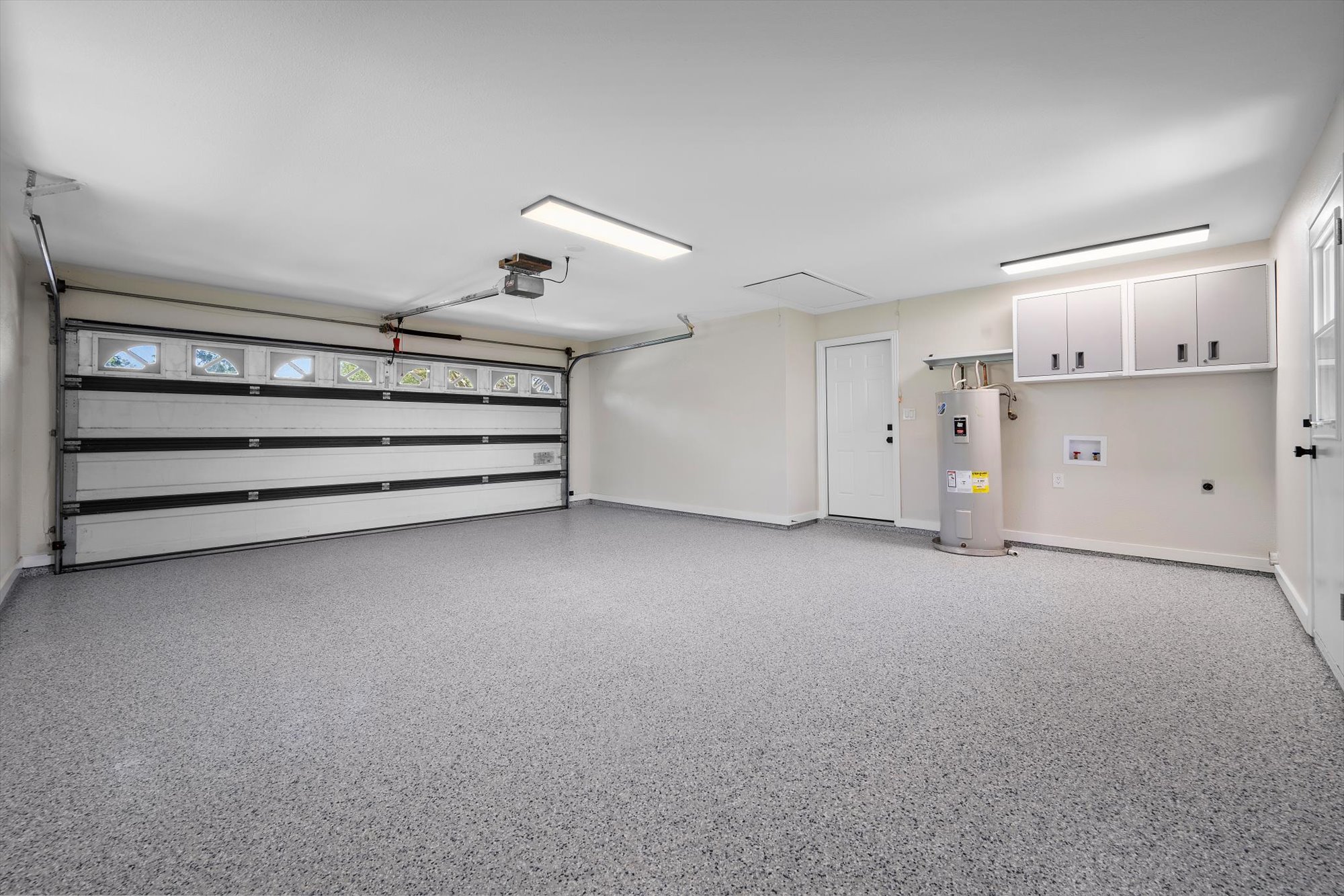 109 Woodland Road Georgetown, TX 78628 - Photo 34 of 40 A pristine garage awaits, featuring a clean epoxy floor, ample storage, and functional lighting.
