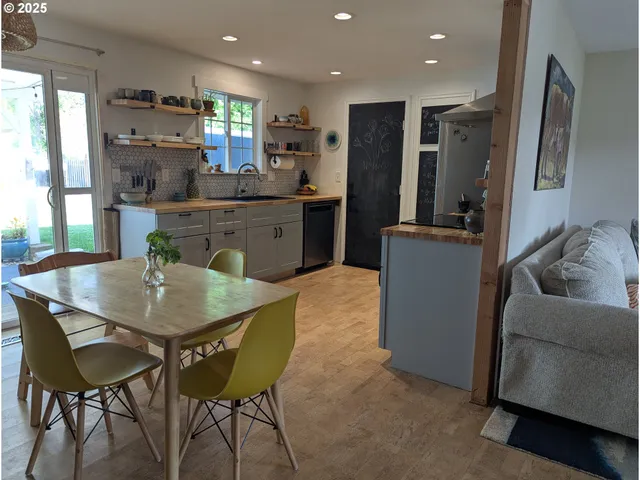 a kitchen with stainless steel appliances granite countertop sink stove refrigerator dining table and chairs