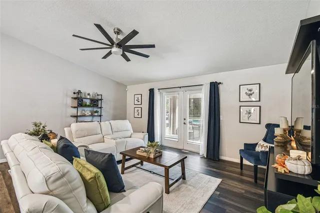 a bedroom with a large bed and a chandelier fan