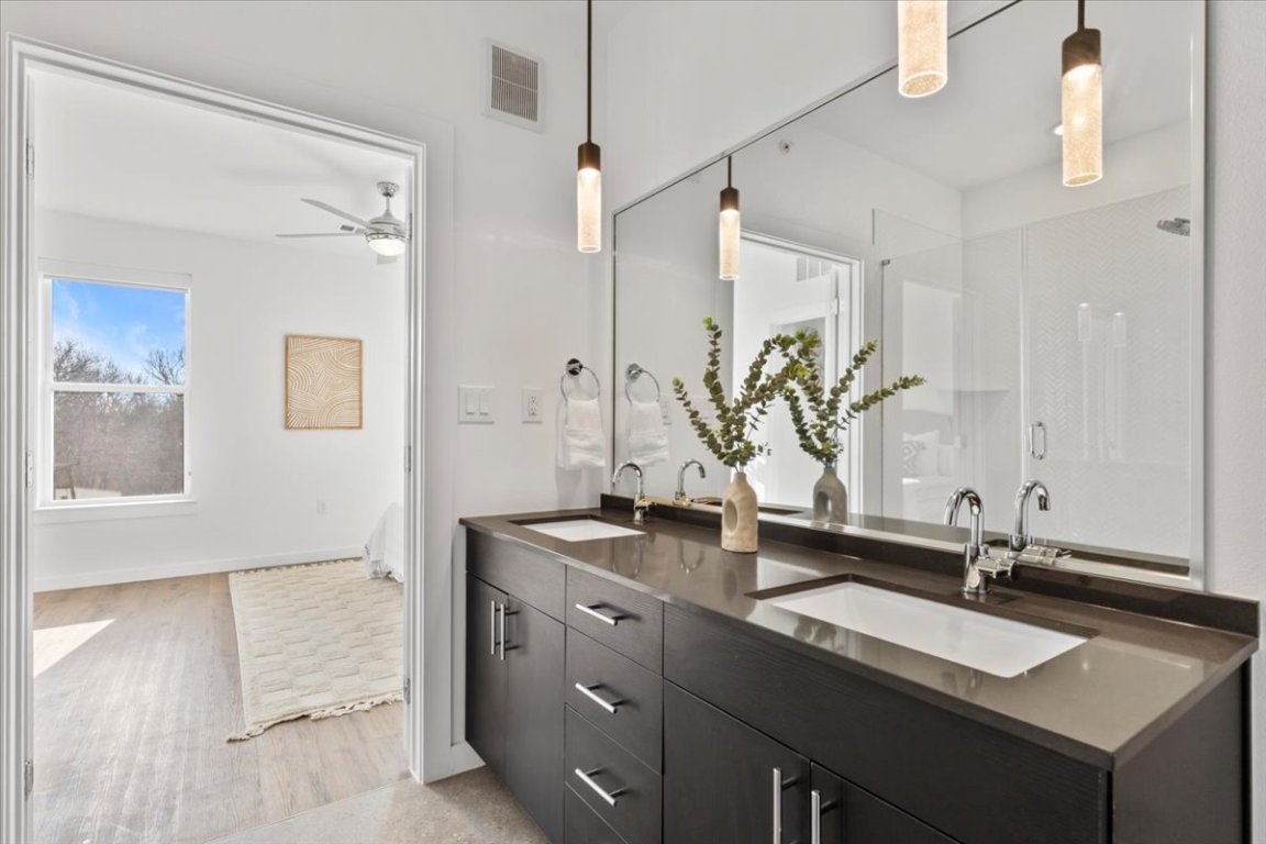 4801 Springdale Road, Unit 1107 Austin, TX 78723 - Photo 15 of 40 Bathroom with double vanity, a stall shower, a ceiling fan, and light wood-style floors