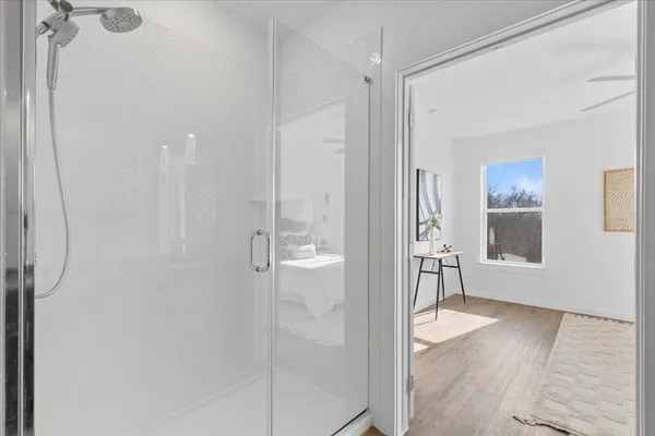 a bathroom with a granite countertop sink a mirror and a shower