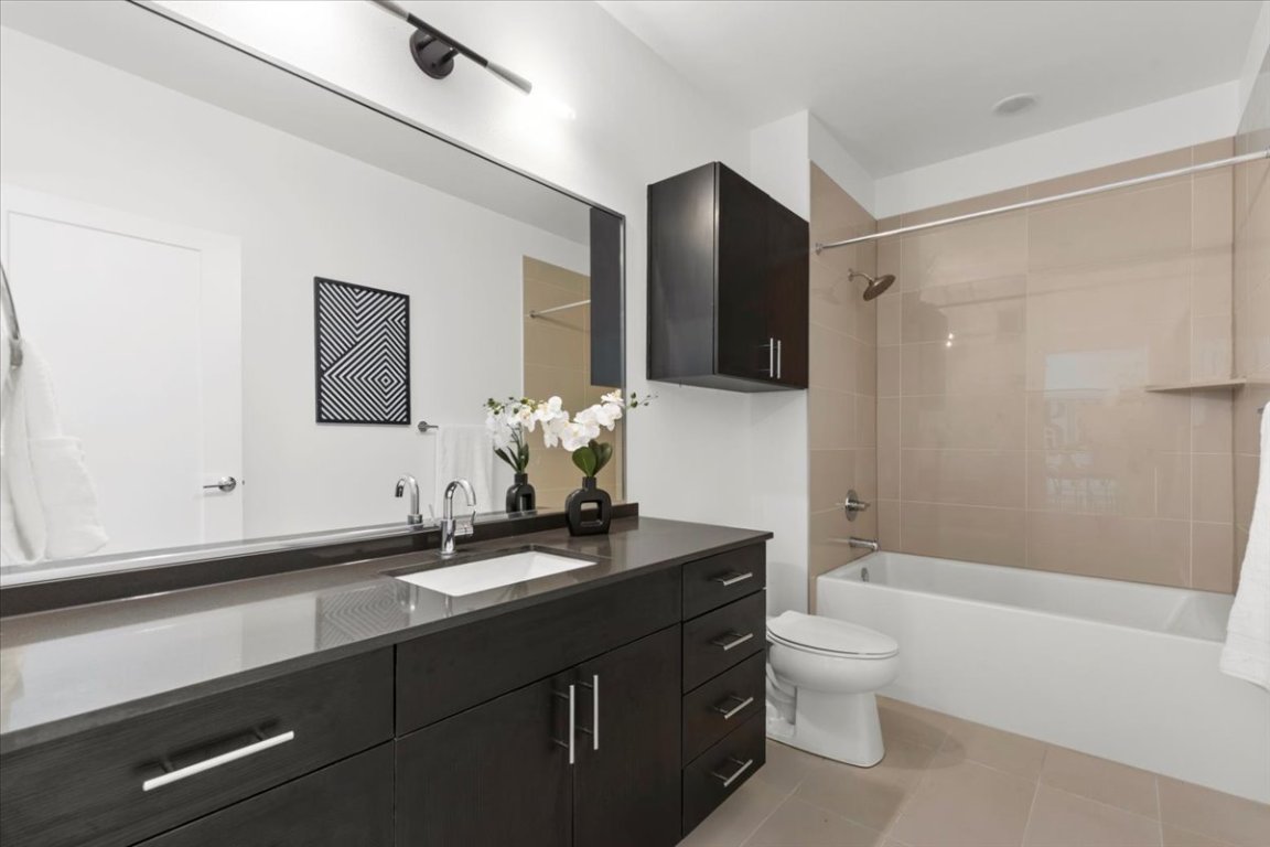 4801 Springdale Road, Unit 1107 Austin, TX 78723 - Photo 21 of 40 Bathroom featuring vanity, tub / shower combination, and light tile patterned flooring