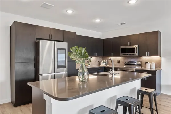 a kitchen with stainless steel appliances granite countertop a sink and a refrigerator