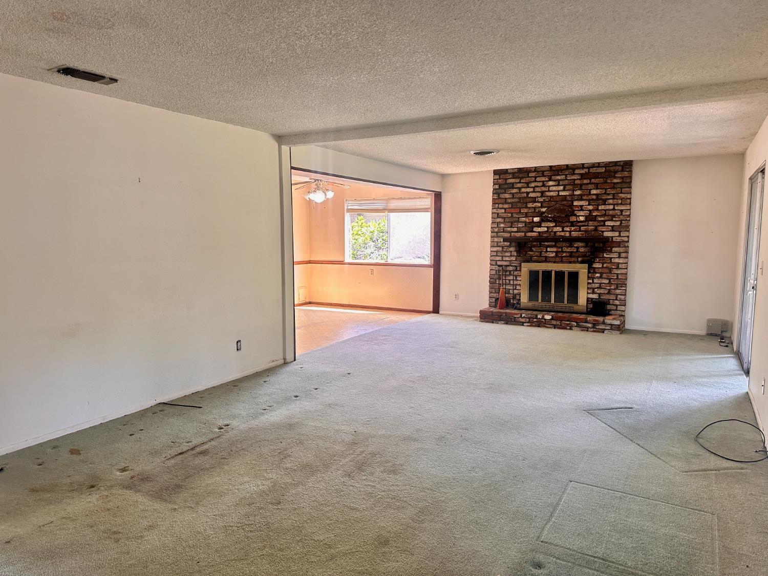 3207 Terry Way Carmichael, CA 95608 - Photo 13 of 36 a view of empty room with a fireplace and window