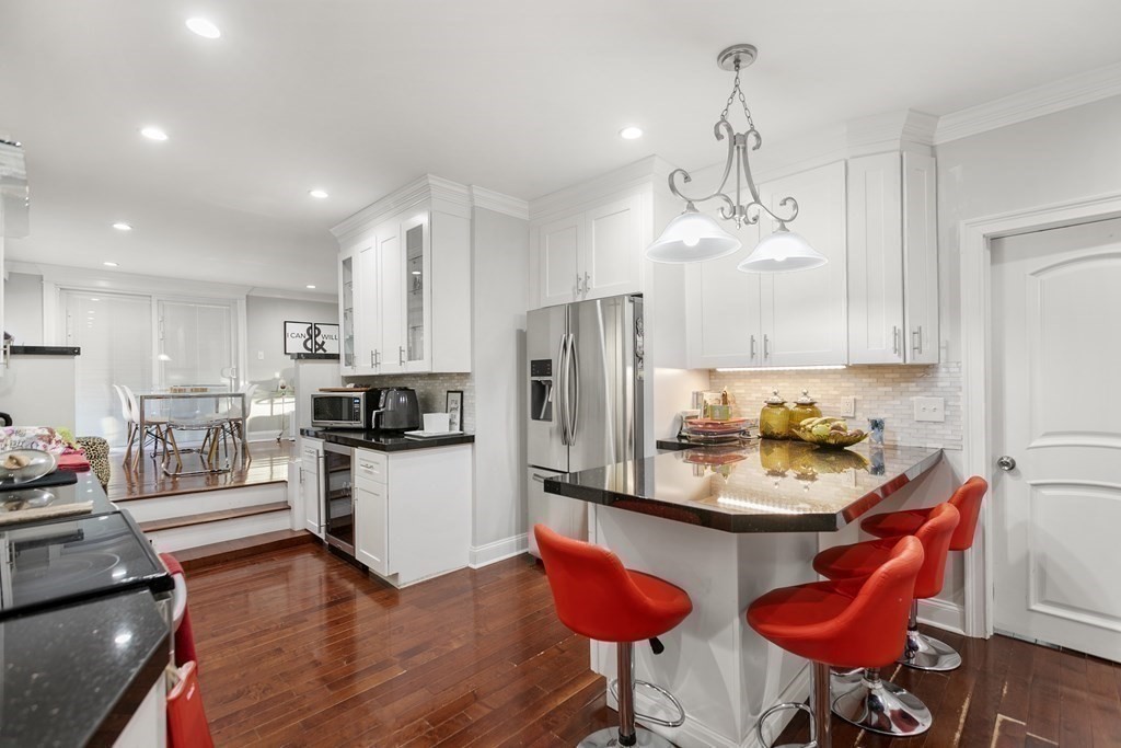 61 Patten Drive Marlborough, MA 01752 - Photo 2 of 20 a kitchen with stainless steel appliances kitchen island granite countertop a refrigerator a stove and white cabinets with wooden floor