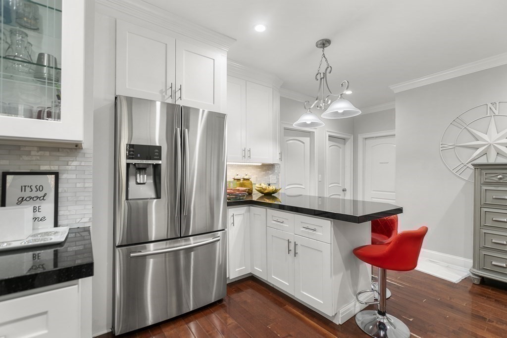 61 Patten Drive Marlborough, MA 01752 - Photo 4 of 20 a kitchen with stainless steel appliances granite countertop a refrigerator a sink dishwasher a dining table and chairs with wooden floor
