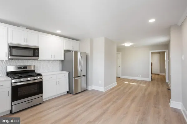 a view of kitchen with stainless steel appliances refrigerator stove microwave and cabinets