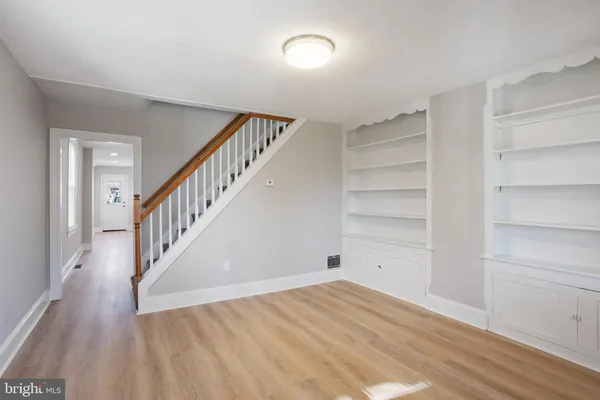 a view of a hallway with wooden floors and stairs
