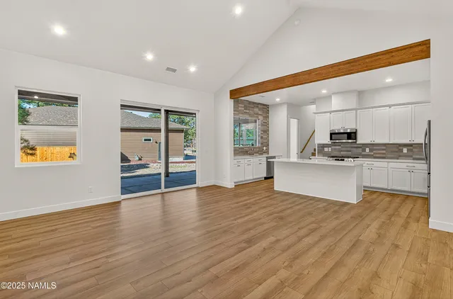 a large kitchen with stainless steel appliances granite countertop a stove and a wooden floors