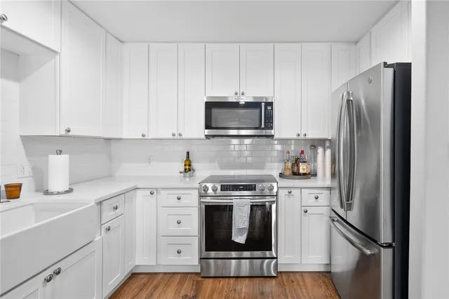 a kitchen with white cabinets and stainless steel appliances