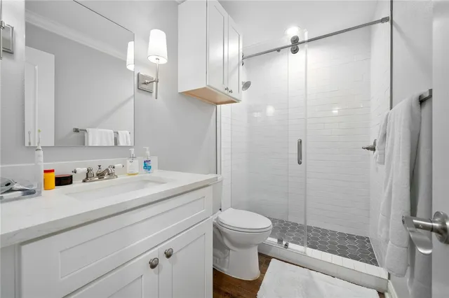a bathroom with a granite countertop sink a toilet and shower