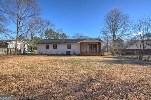 a front view of house with yard and trees around