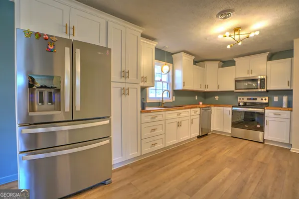 a kitchen with granite countertop white cabinets and stainless steel appliances