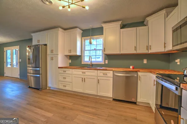 a kitchen with stainless steel appliances granite countertop a refrigerator a stove and a sink