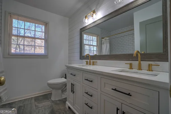 a bathroom with a toilet sink and mirror