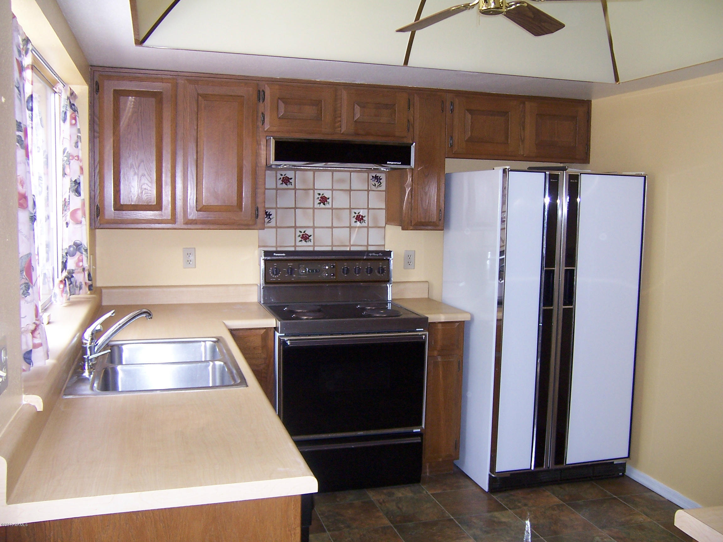 548 East Calavar Road Phoenix, AZ 85022 - Photo 9 of 32 a kitchen with white cabinets and stainless steel appliances