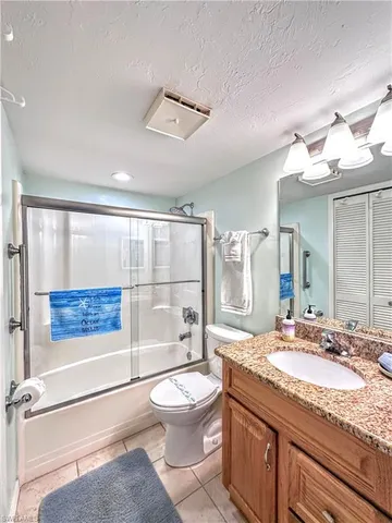 a bathroom with a granite countertop sink mirror vanity and toilet