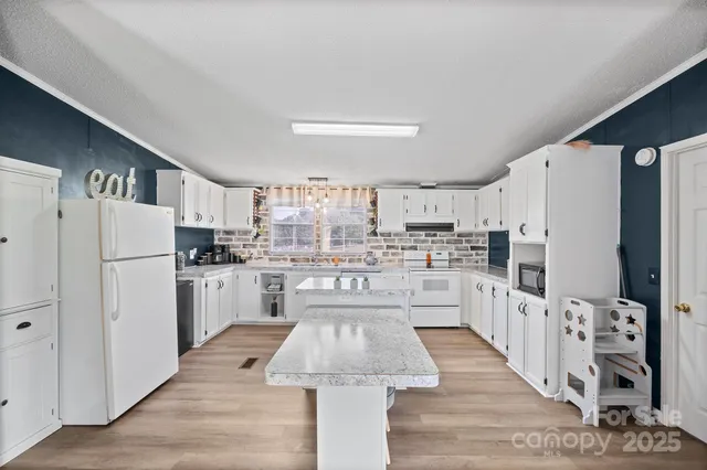 a large white kitchen with cabinets