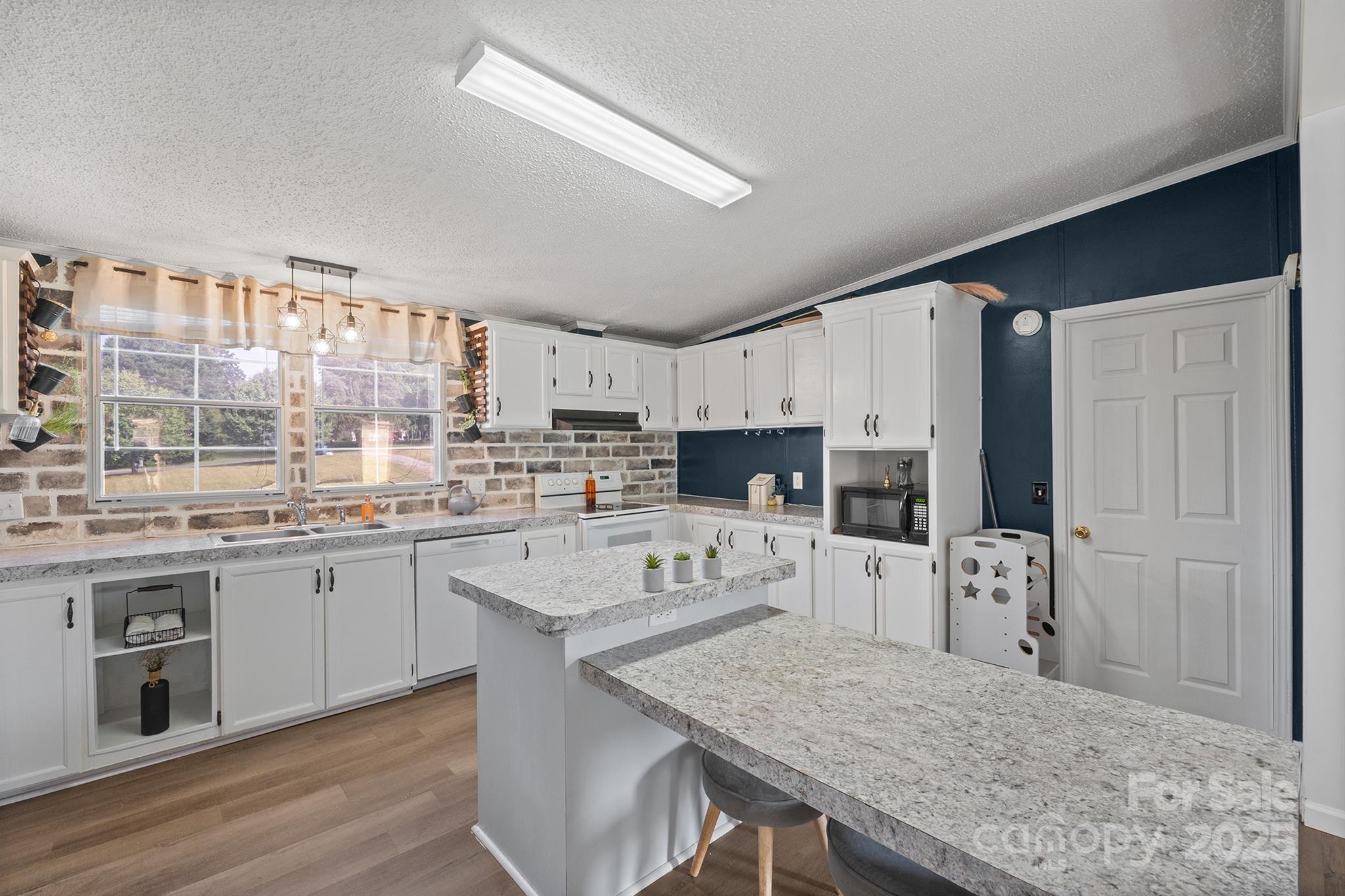 10483 Troutman Road Midland, NC 28107 - Photo 9 of 21 a kitchen with granite countertop a sink stove and refrigerator