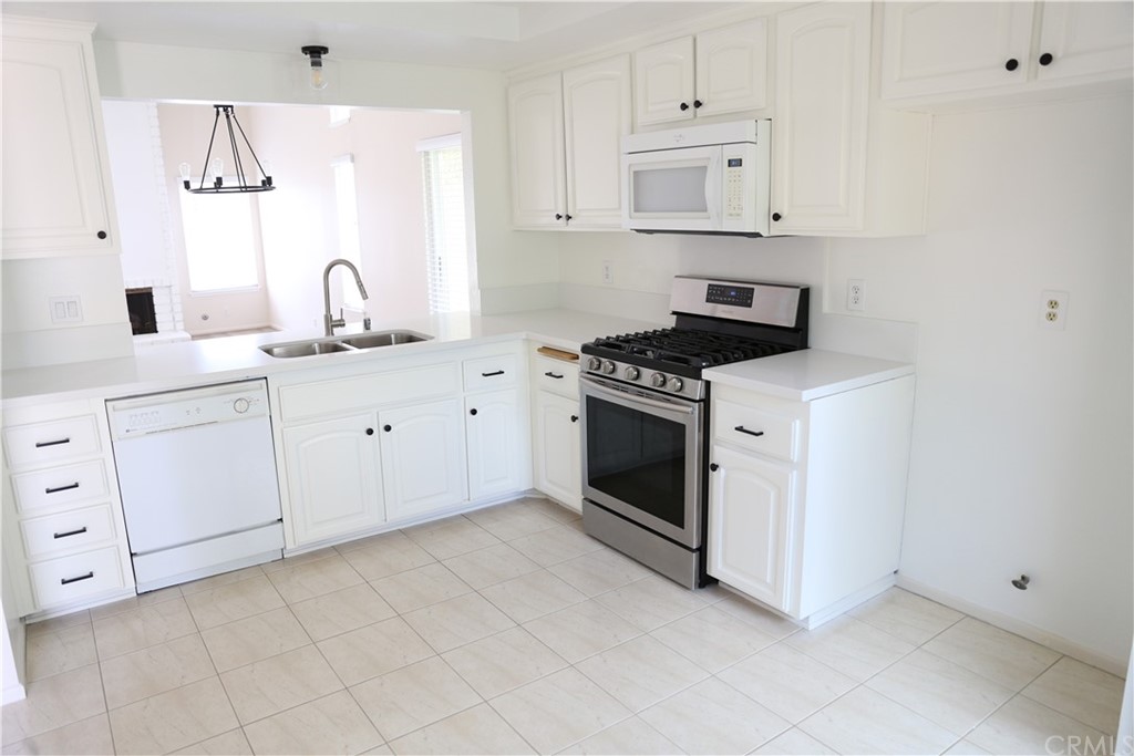 8462 Basin Circle Huntington Beach, CA 92646 - Photo 4 of 29 a kitchen with white cabinets and white appliances