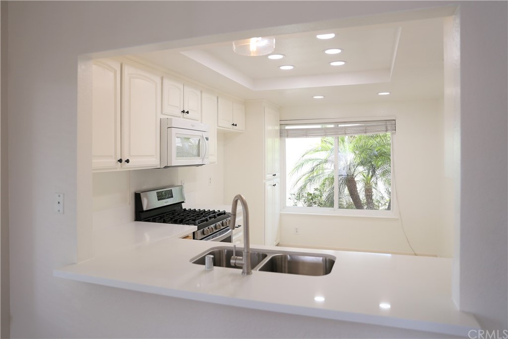 8462 Basin Circle Huntington Beach, CA 92646 - Photo 5 of 29 a kitchen with stainless steel appliances a sink a stove and a window