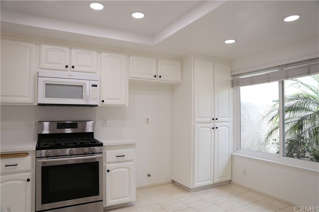 8462 Basin Circle Huntington Beach, CA 92646 - Photo 6 of 29 a kitchen with white cabinets and appliances