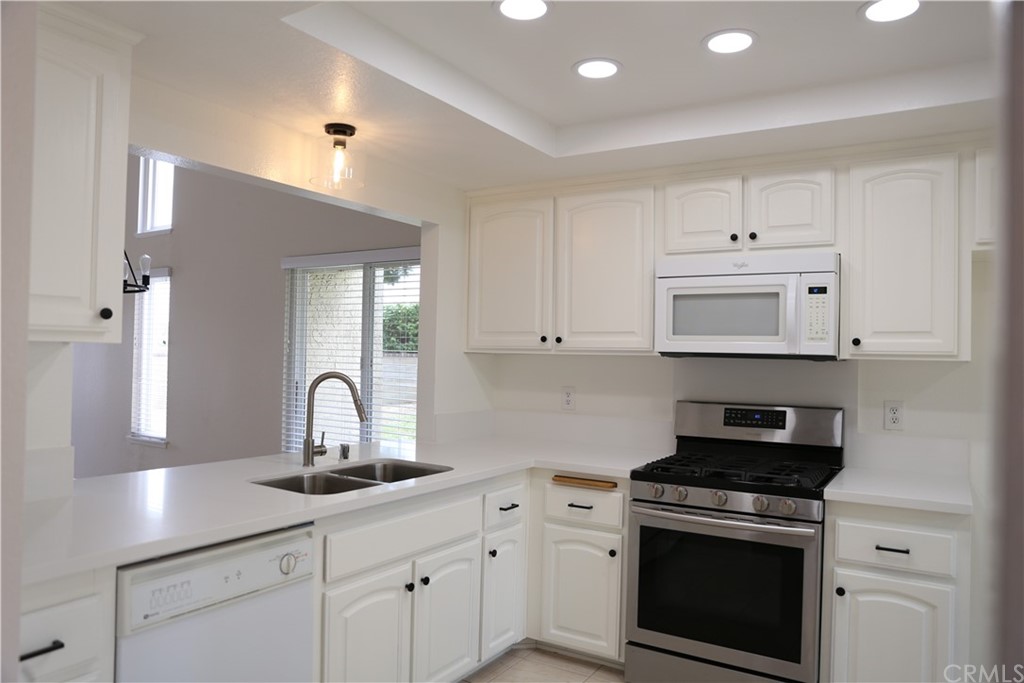 8462 Basin Circle Huntington Beach, CA 92646 - Photo 7 of 29 a kitchen with white cabinets and appliances