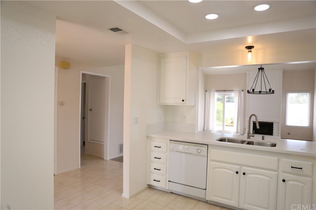 8462 Basin Circle Huntington Beach, CA 92646 - Photo 9 of 29 a kitchen with white cabinets and window