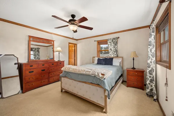 a bedroom with a bed dresser and wooden floor