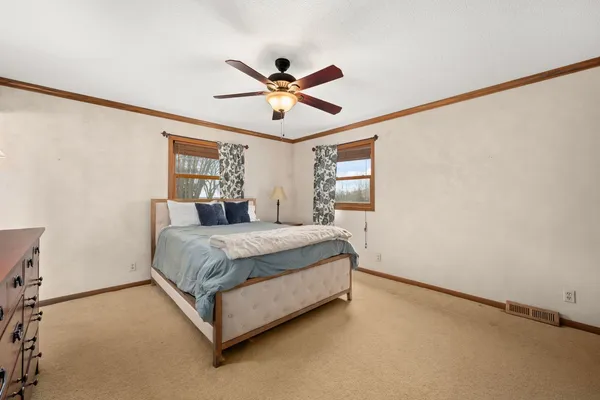 a spacious bedroom with a bed and a window