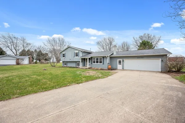 a front view of house with yard and garage