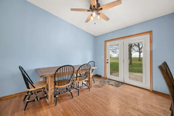 a dining room with wooden floor a chandelier a glass table and chairs