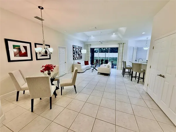 a living room with furniture and a dining table with kitchen appliances